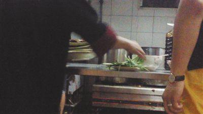 7月23日，漢麗軒烤肉超市昌平店，服務(wù)員將幾盤顧客剩菜（左手中疊在一起的是幾盤肉，其右手正整理韭菜）端回后廚，進(jìn)行整理后準(zhǔn)備再送往餐廳自助取餐區(qū)供顧客食用。